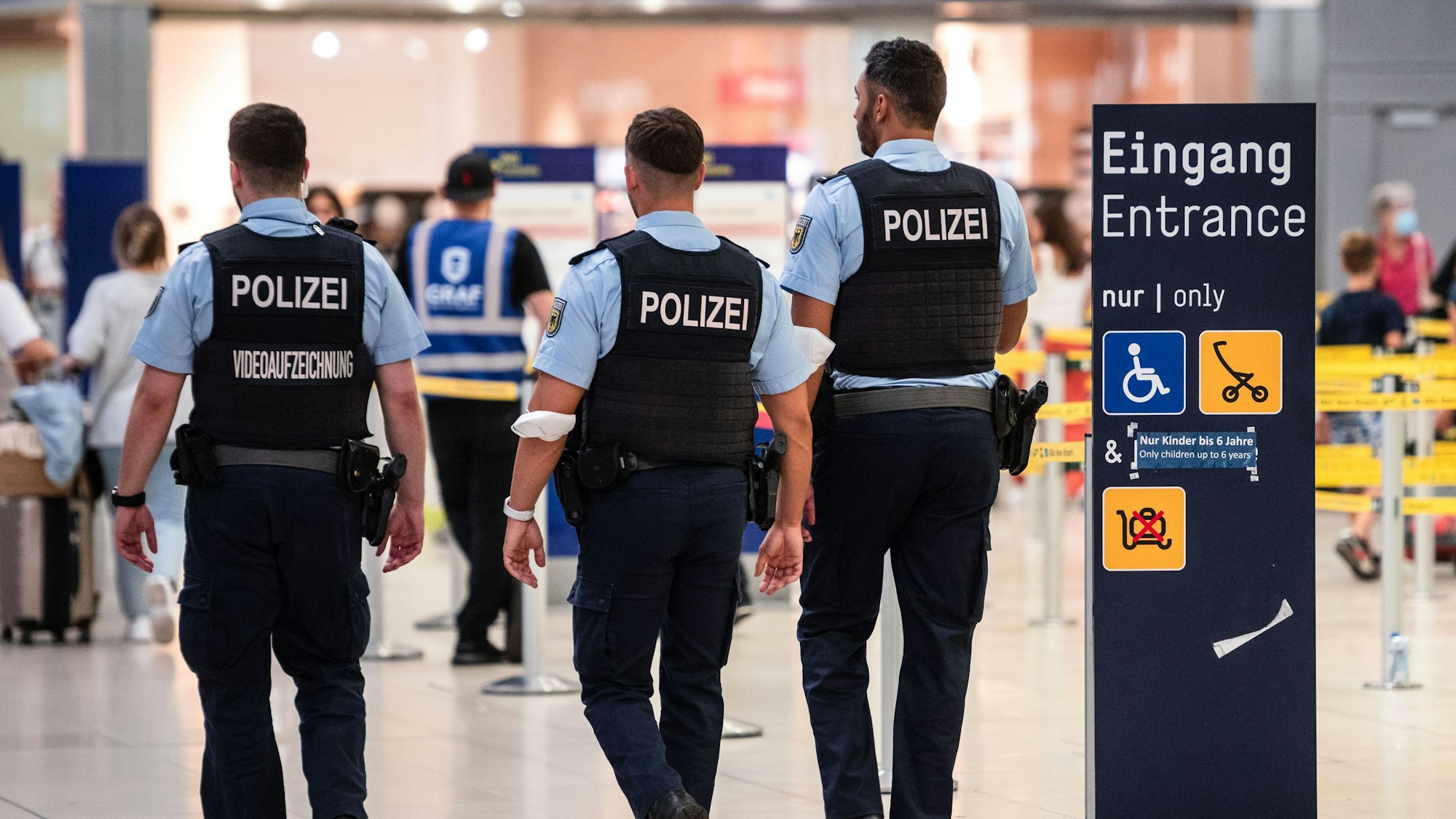 Beamte der Bundespolizei gehen an den Sicherheitskontrollen des Flughafens Köln/Bonn vorbei.  (Archivbild)