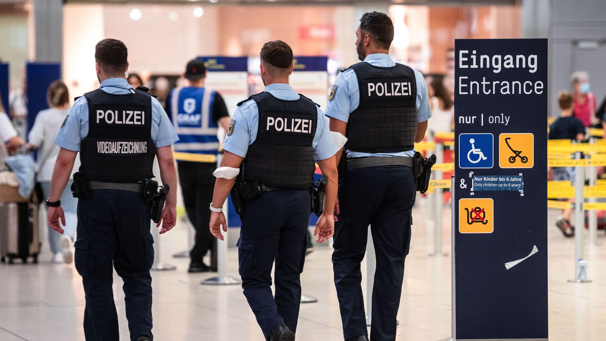 Beamte der Bundespolizei gehen an den Sicherheitskontrollen des Flughafens Köln/Bonn vorbei.