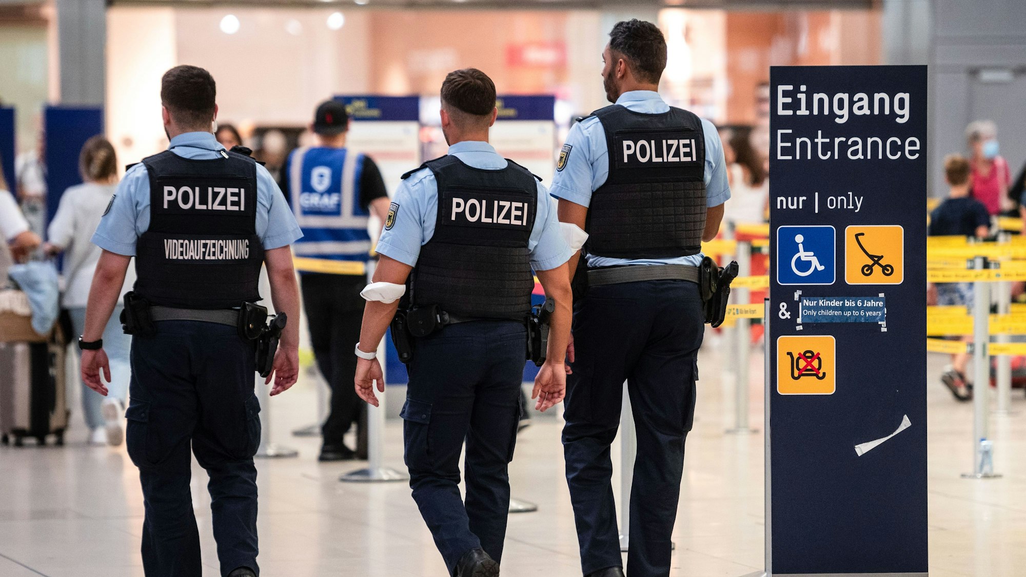 Beamte der Bundespolizei gehen an den Sicherheitskontrollen des Flughafens Köln/Bonn vorbei.