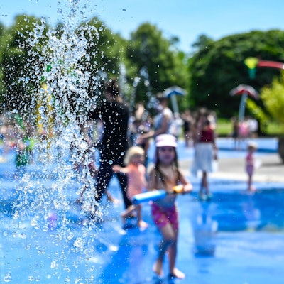 Der Wasserspielplatz im Grüngürtel an der Venloer Straße, ein paar Kinder turnen unter den Strahlen herum.