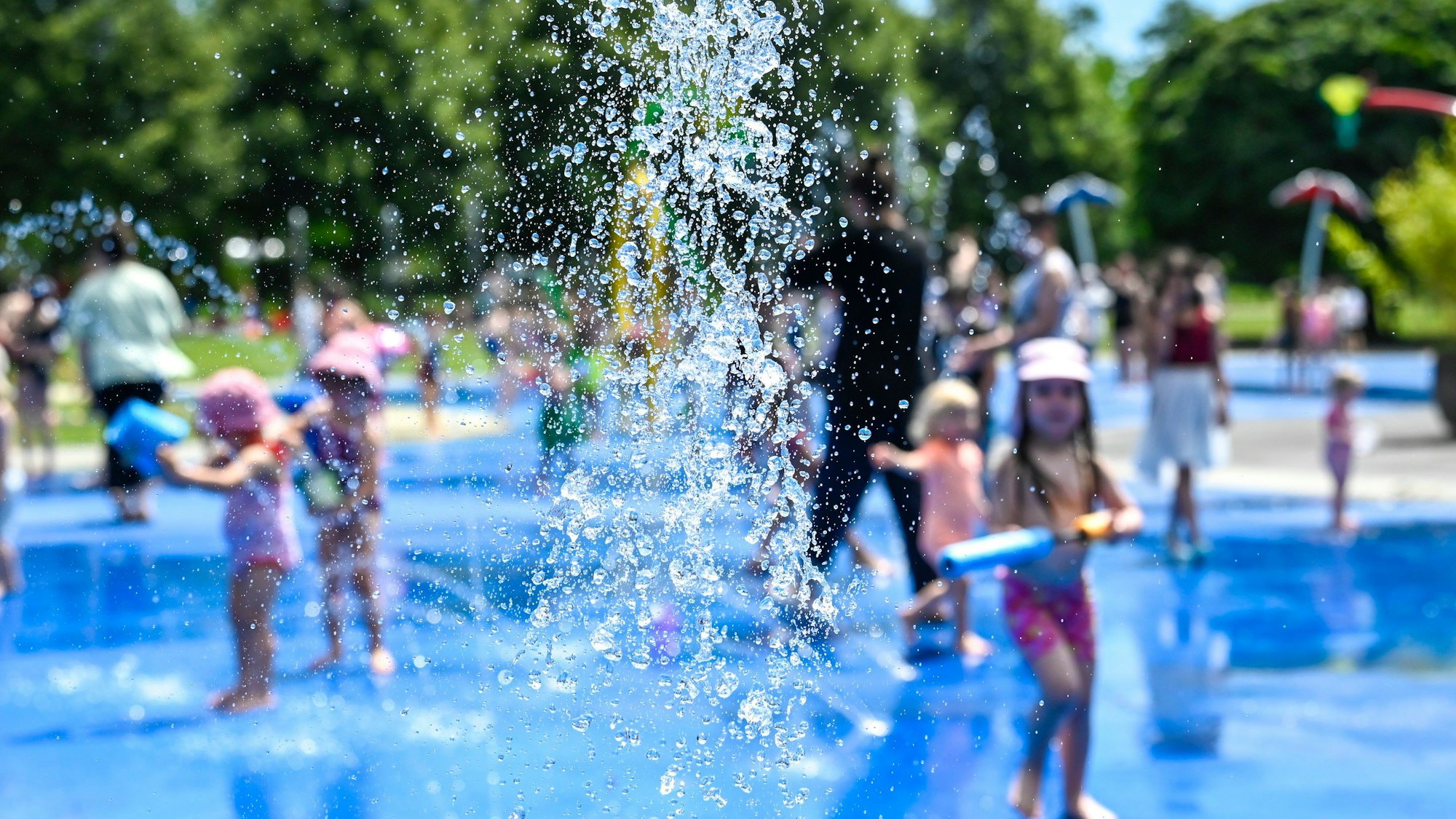 Der Wasserspielplatz im Grüngürtel an der Venloer Straße, ein paar Kinder turnen unter den Strahlen herum.