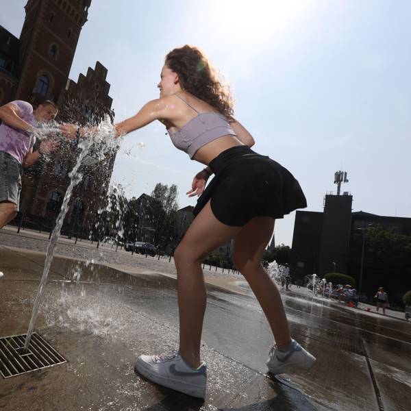 Gegen die Hitze: Zwei Kölner kühlen sich an einem Brunnen ab.