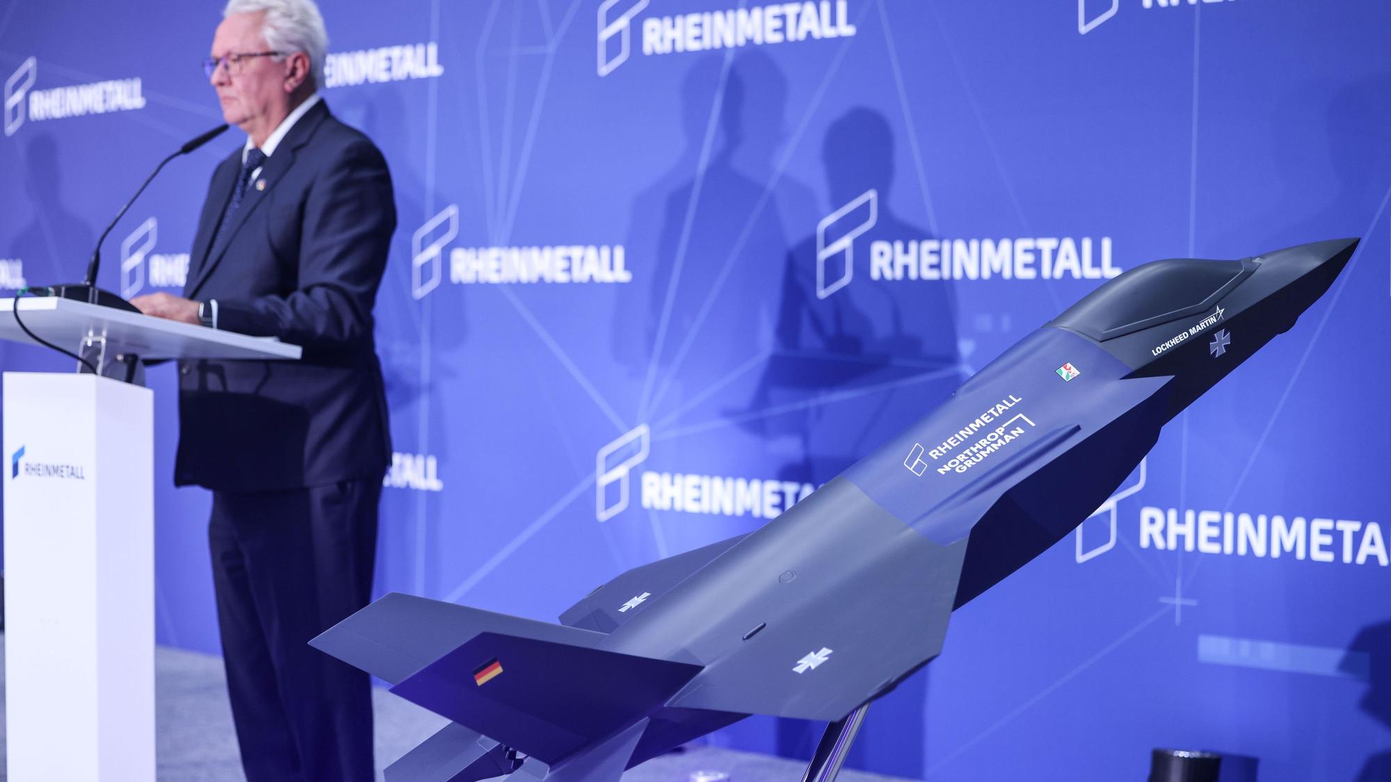 01.07.2025, Nordrhein-Westfalen, Weeze: Armin Papperger, Vorstandsvorsitzender des Rüstungskonzerns Rheinmetall, spricht im Werk der Rheinmetall Aviation Service GmbH in Weeze beim Besuch des Ministerpräsidenten hinter einem Modell des F35 Kampfjets. Auf rund 60.000 Quadratmetern errichtet Rheinmetall eine Fabrik für den militärischen Flugzeugbau. Dort sollen ab Sommer 2025 Rumpfmittelteile für den F-35-Kampfjet gefertigt werden. Foto: Oliver Berg/dpa +++ dpa-Bildfunk +++