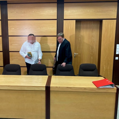 Das Bild zeigt den Angeklagten mit seinem Verteidiger.