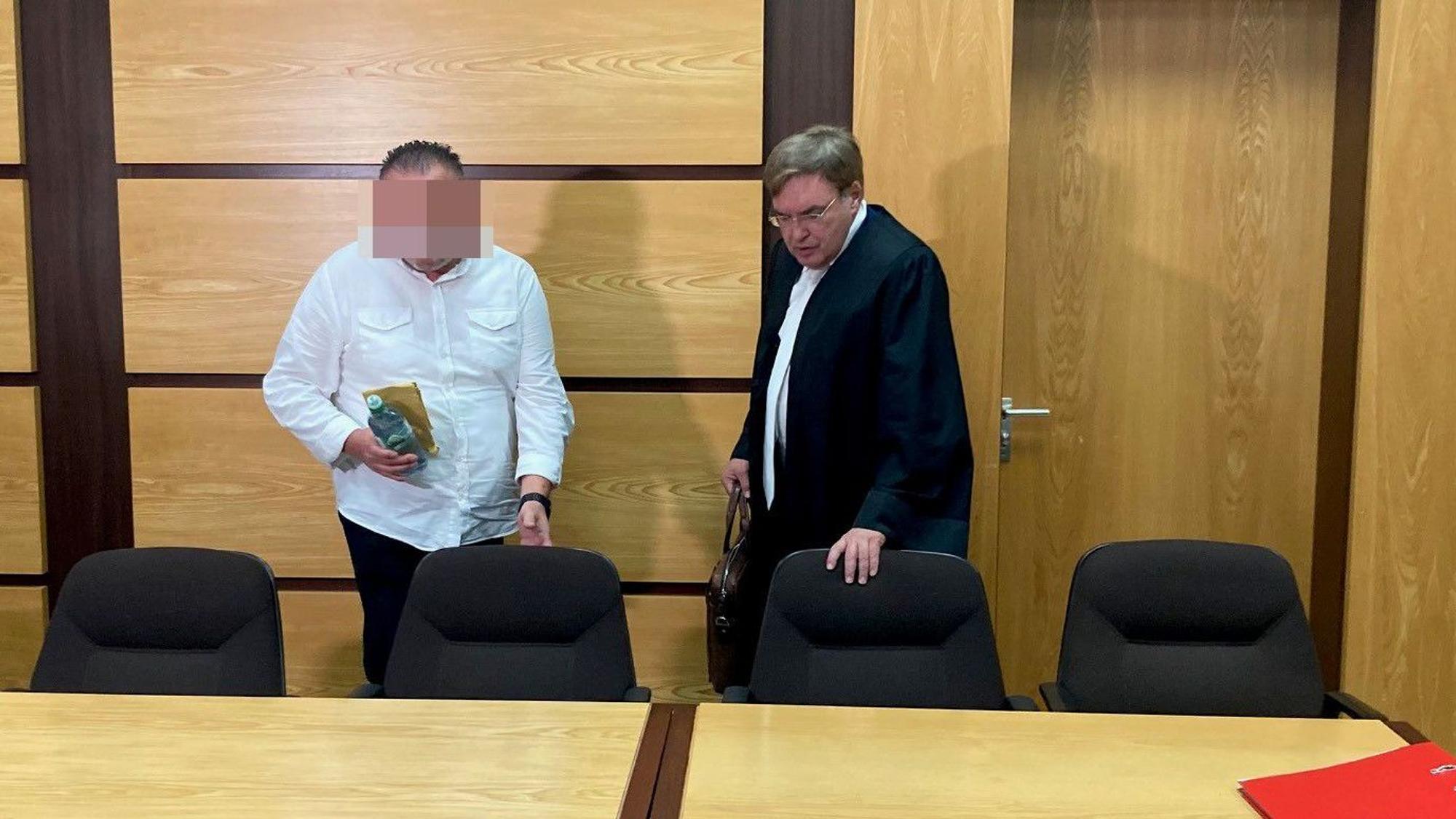 Das Bild zeigt den Angeklagten mit seinem Verteidiger.