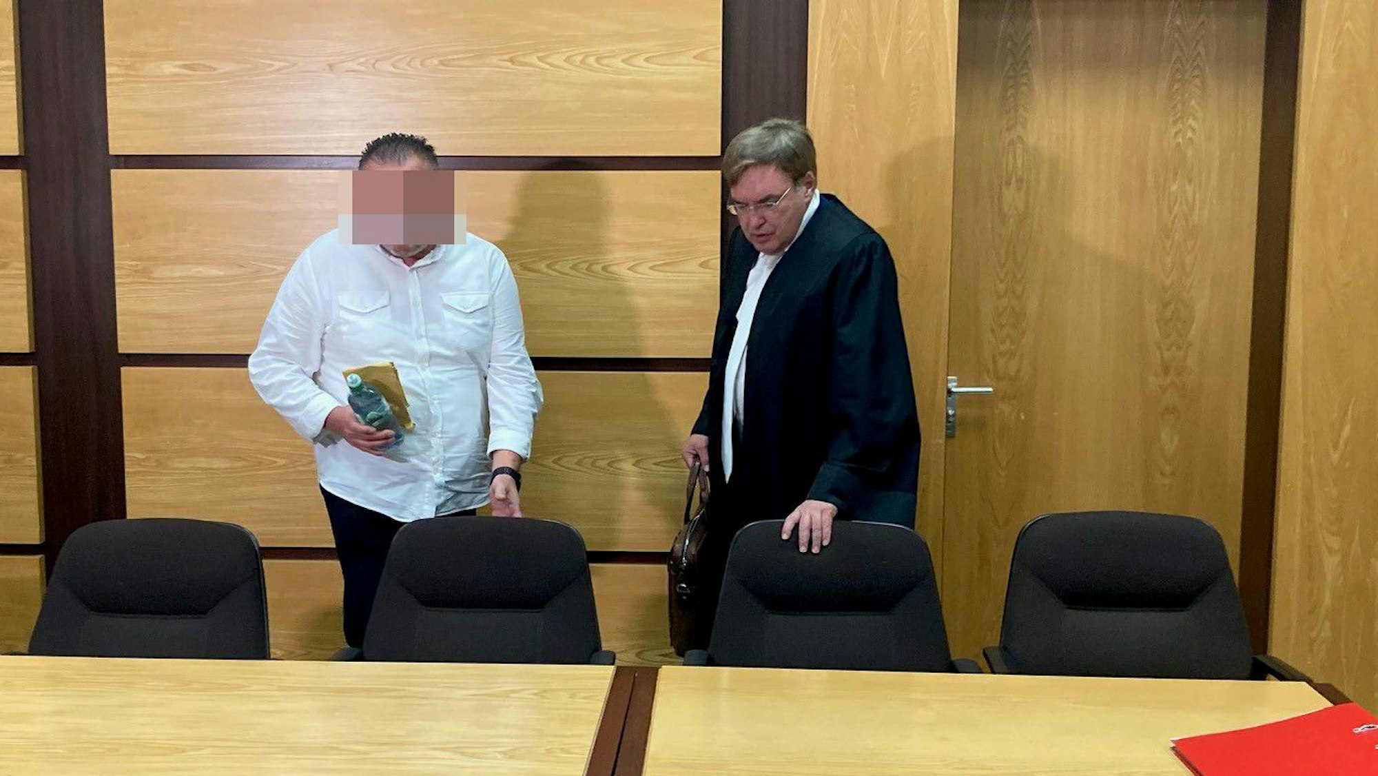 Das Bild zeigt den Angeklagten mit seinem Verteidiger.