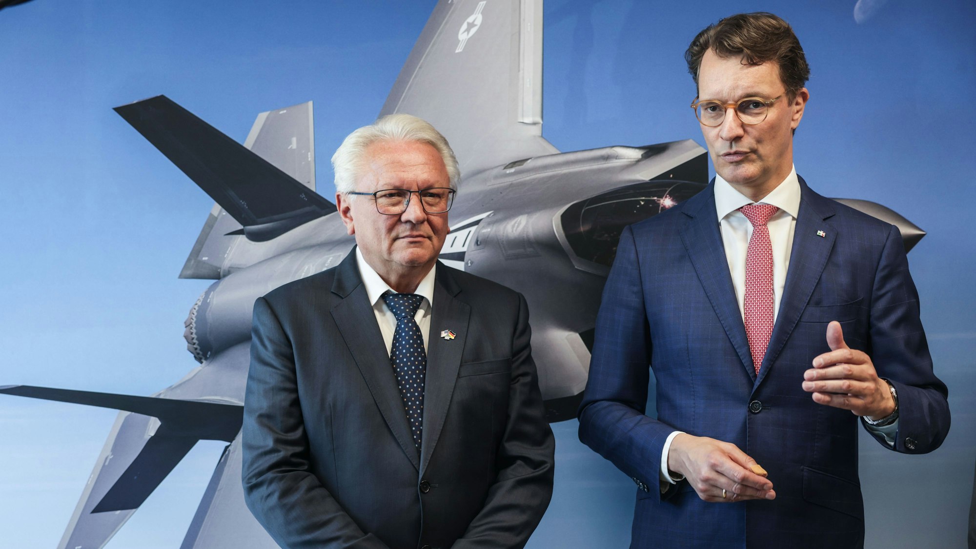 01.07.2025, Nordrhein-Westfalen, Weeze: Armin Papperger (l), Vorstandsvorsitzender des Rüstungskonzerns Rheinmetall und Hendrik Wüst (CDU, r), Ministerpräsident von Nordrhein-Westfalen, sprechen im Werk der Rheinmetall Aviation Service GmbH in Weeze nach dem Besuch des Ministerpräsidenten zu Journalisten. Auf rund 60.000 Quadratmetern errichtet Rheinmetall eine Fabrik für den militärischen Flugzeugbau. Dort sollen ab Sommer 2025 Rumpfmittelteile für den F-35-Kampfjet gefertigt werden. Foto: Oliver Berg/dpa +++ dpa-Bildfunk +++