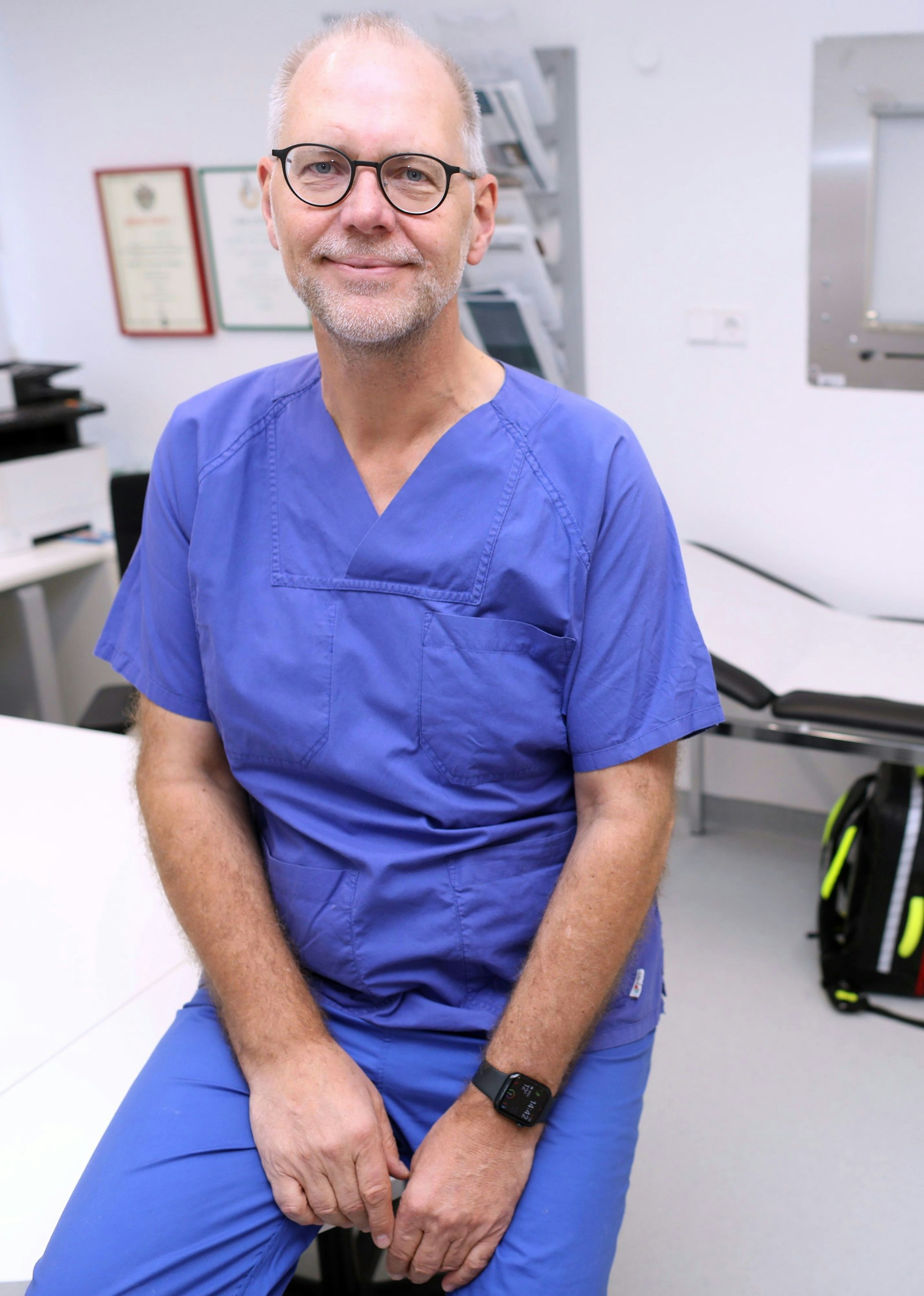 Professor Arno Dormann ist in Arztkleidung in einem Behandlungszimmer zu sehen.