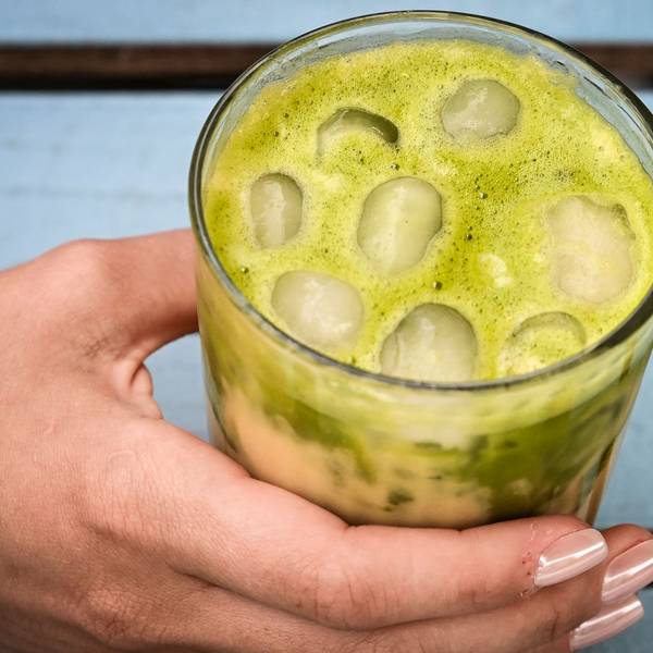 23.06.2025, Berlin: Eine junge Frau trinkt einen Iced Matcha Latte.
