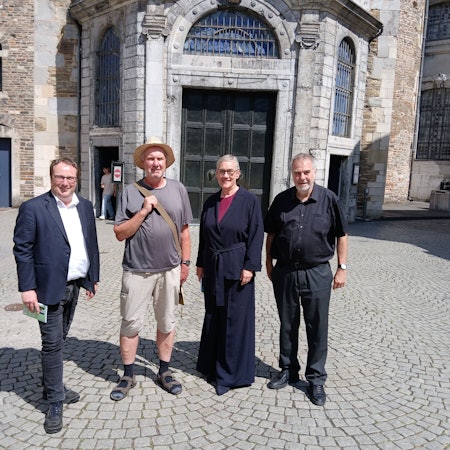 Vor der Aachener Dompforte stehen Oliver Krischer, Ralf Spilles, Sibylle Keupen und Rolf-Peter Cremer.