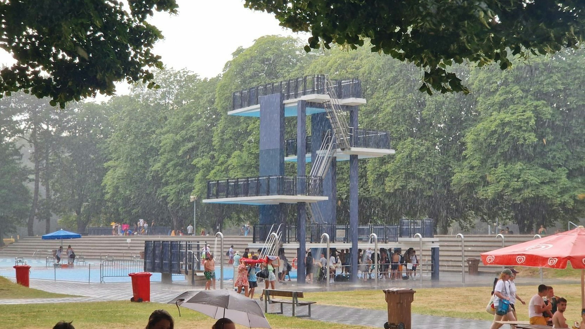 Badegäste verlassen ein Freibad wegen eines Unwetters.