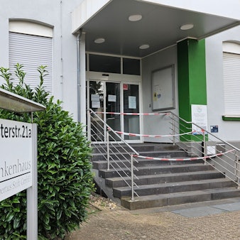 Zu sehen ist der mit rot-weißem Flatterband versperrte Haupteingang des Bedburger Krankenhauses.