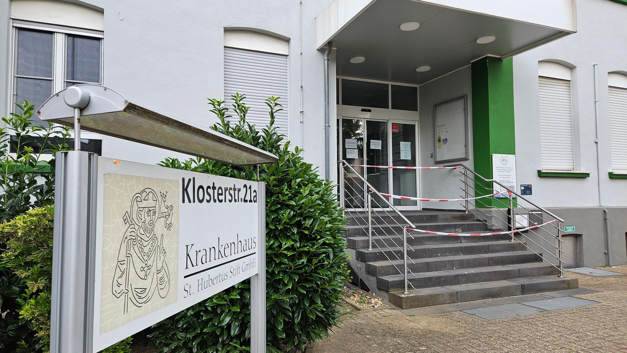 Das Bild zeigt den Eingang des Bedburger Krankenhauses. Es ist Absperrband vor der Eingangstreppe zu sehen.