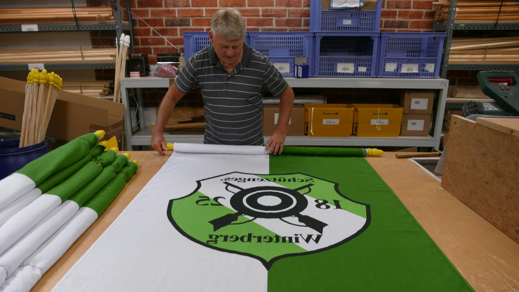 Ein Mann rollte eine grün-weiße Fahne auf.