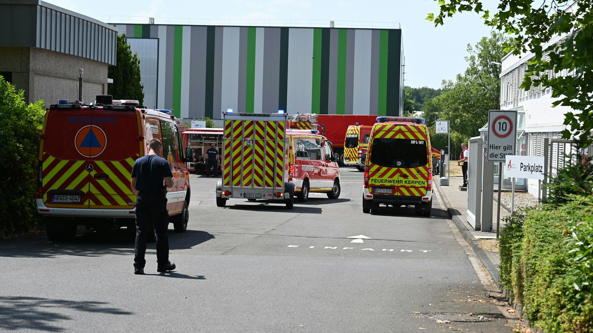 Das Bild zeigt mehrere Feuerwehrfahrzeuge auf einem Firmengelände.
