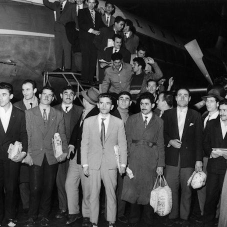 55 Gastarbeiter steigen aus einem Flugzeug.