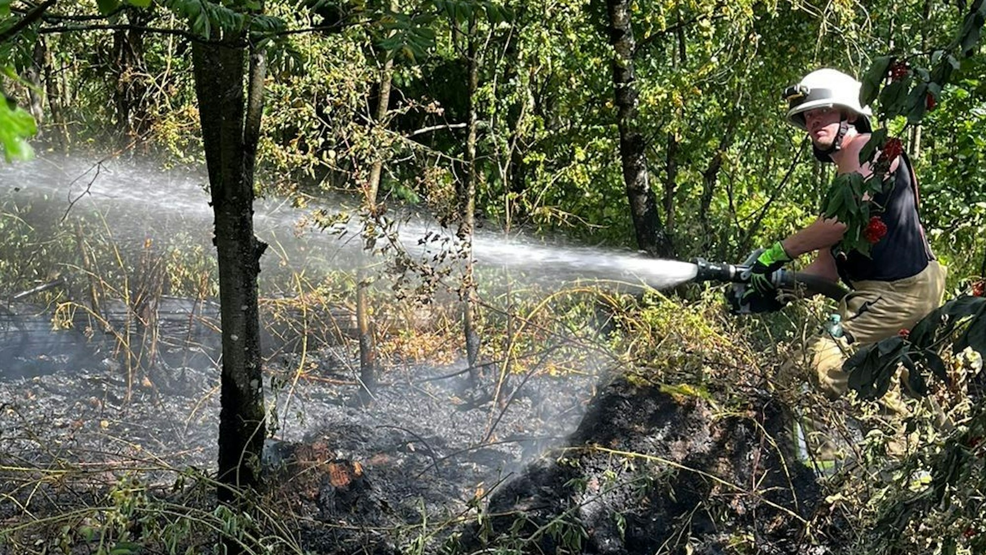Feuerwehrmann geht gegen die Flammen vor.