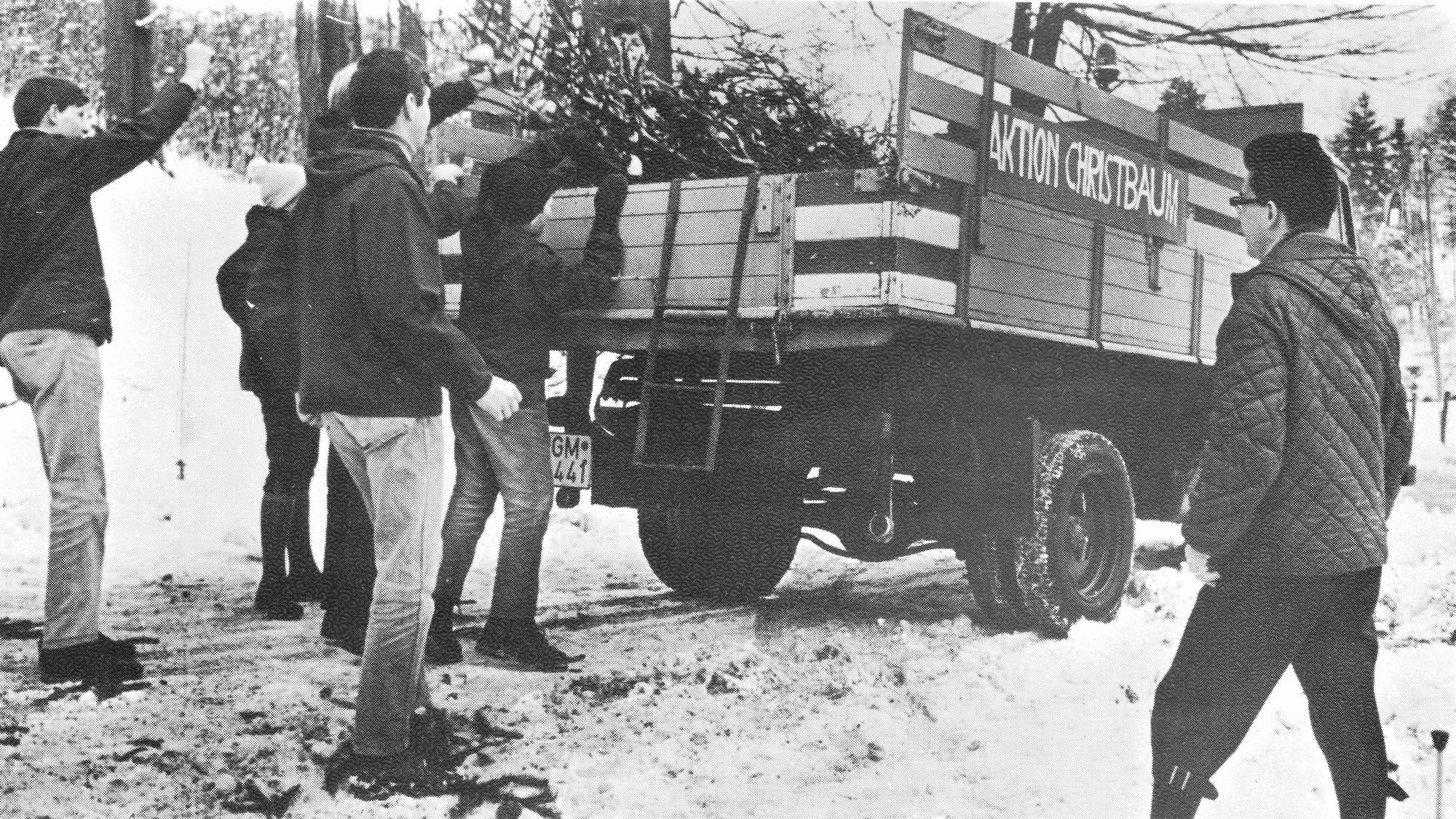 CVJM-Mitglieder wuchten in Gummersbach abgeschmückte Weihnachtsbäume zwecks Abtransport auf ein Fahrzeug.