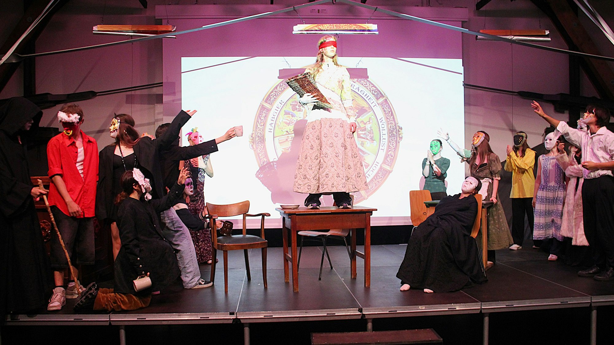 Schülerinnen und Schüler des Kurses UNESCO-Weltkultur präsentieren auf der Bühne der Aula des Hansa-Gymnasiums ihr Theaterstück „todsuenden.exe“.