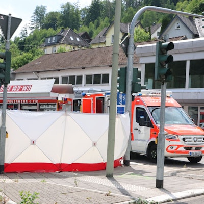 Einsatzfahrzeuge neben einem Sichtschutz.