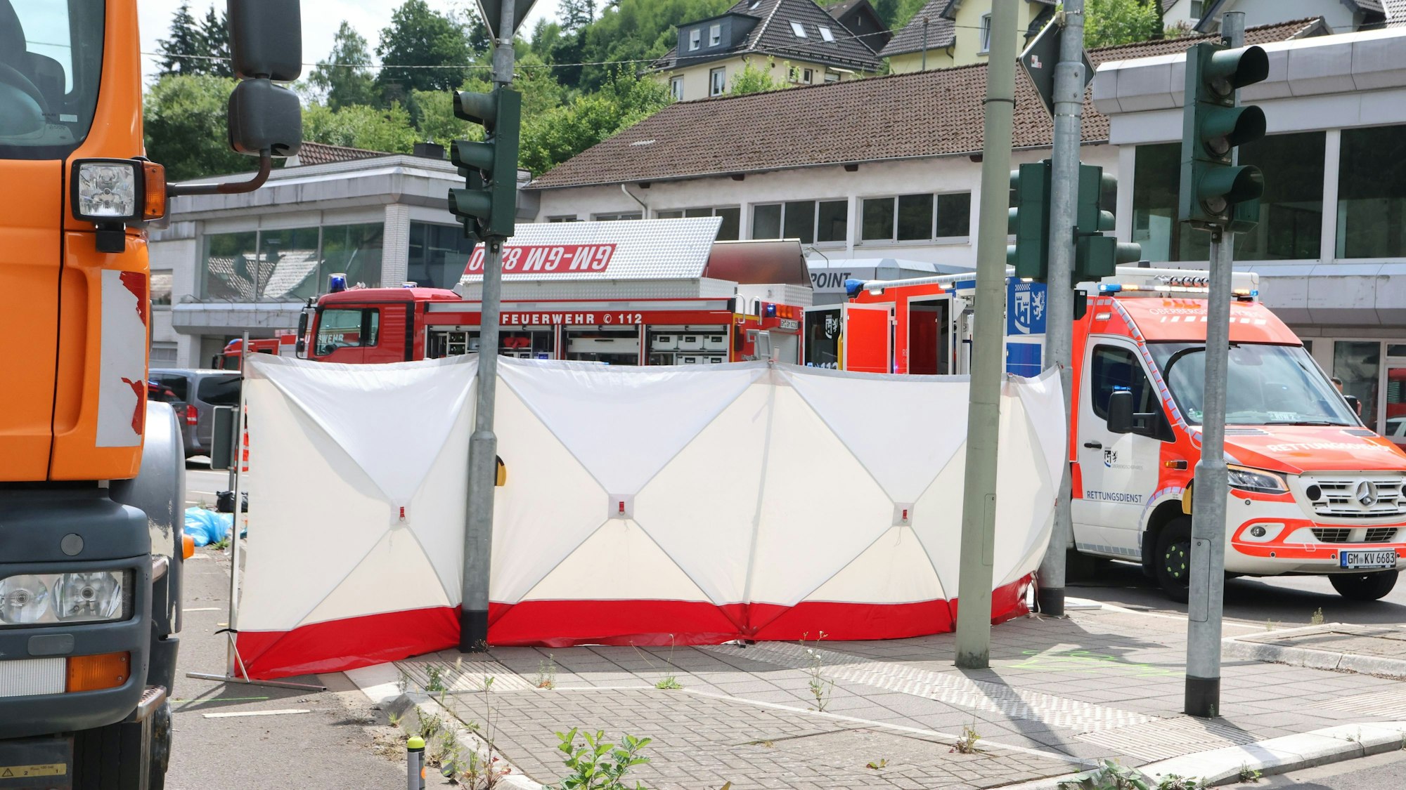 Einsatzfahrzeuge neben einem Sichtschutz.