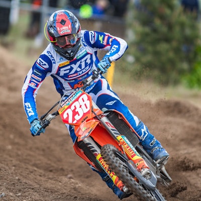 Zu sehen ist ein Motocross-Fahrer der durch den Schlamm fährt.