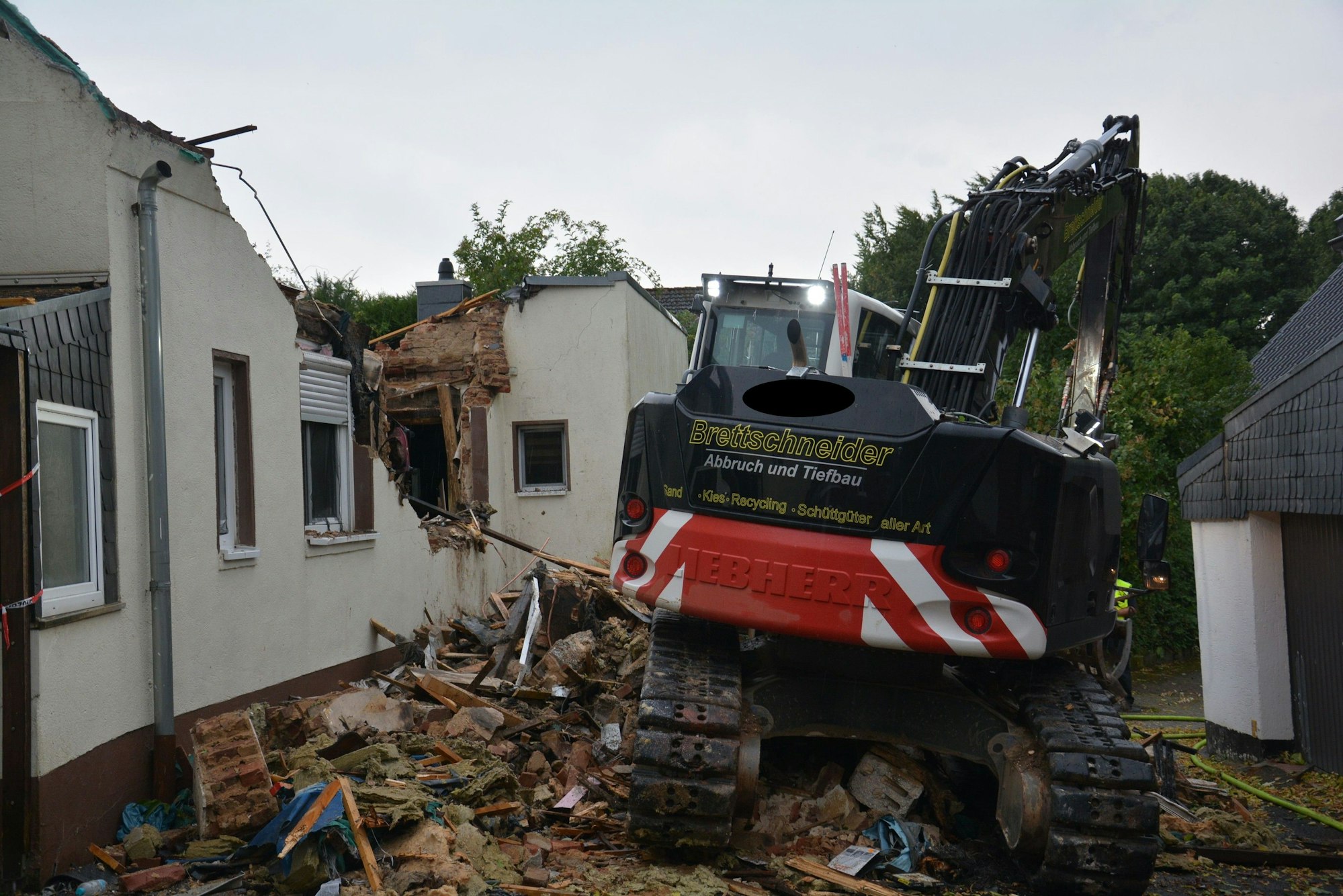 Das Bild zeigt einen Bagger an einem abgerissen Haus.