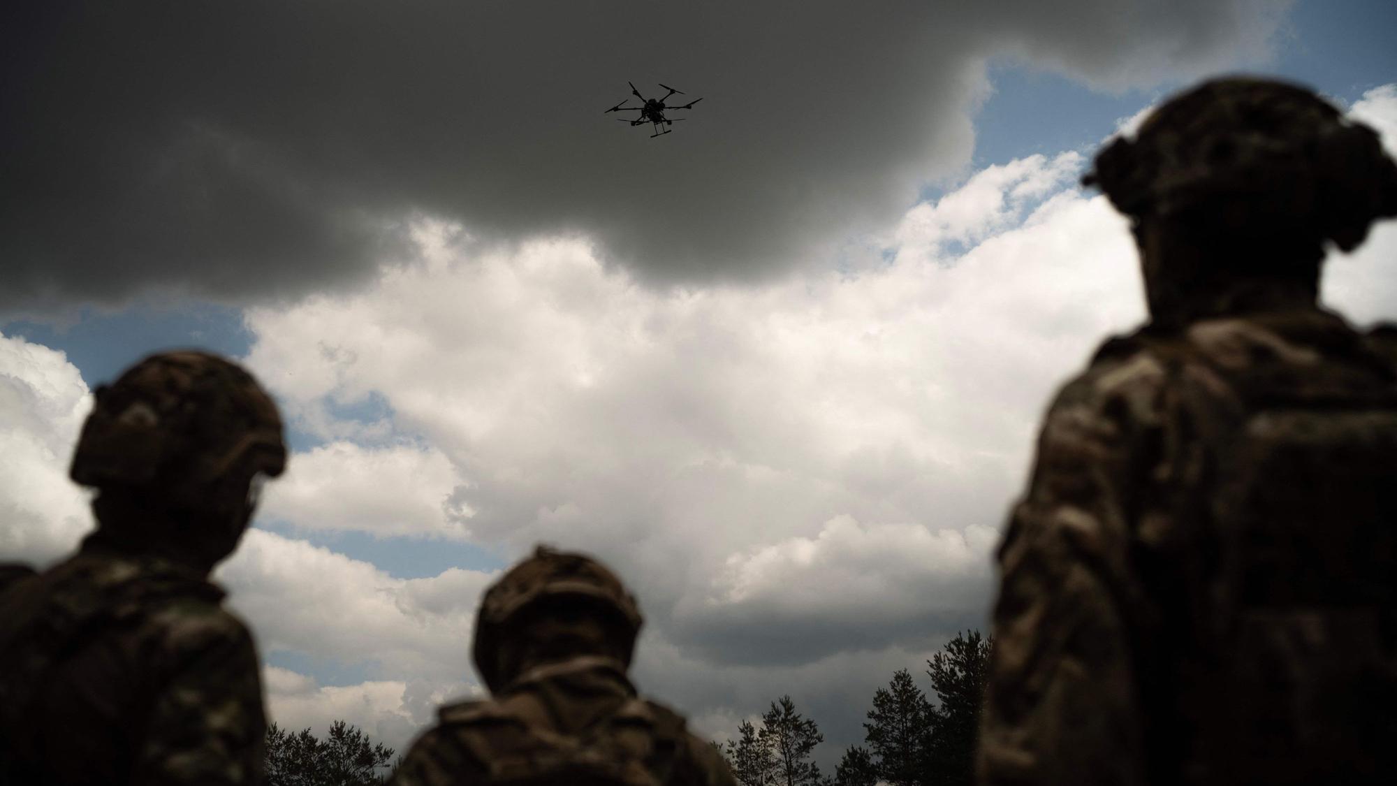 Soldiers from the "Black Sky" battalion of the Spartan brigade look at an agricultural drone, transformed into a front-line delivery cargo, during a demonstration for AFP, at an undisclosed location not far from the front line, in the region of Dnipropetrovsk, Ukraine, on June 14, 2025, amid the russian invasion of Ukraine. Ukrainian army logistics have become the priority target for Russian drones. The technological and financial growth of the Russian drone industry is forcing the Ukrainian army to adapt by building new means of transport and logistical deliveries, such as buggies, motorbikes and cargo delivery drones, using whatever resources are available. (Photo by Florent VERGNES / AFP)