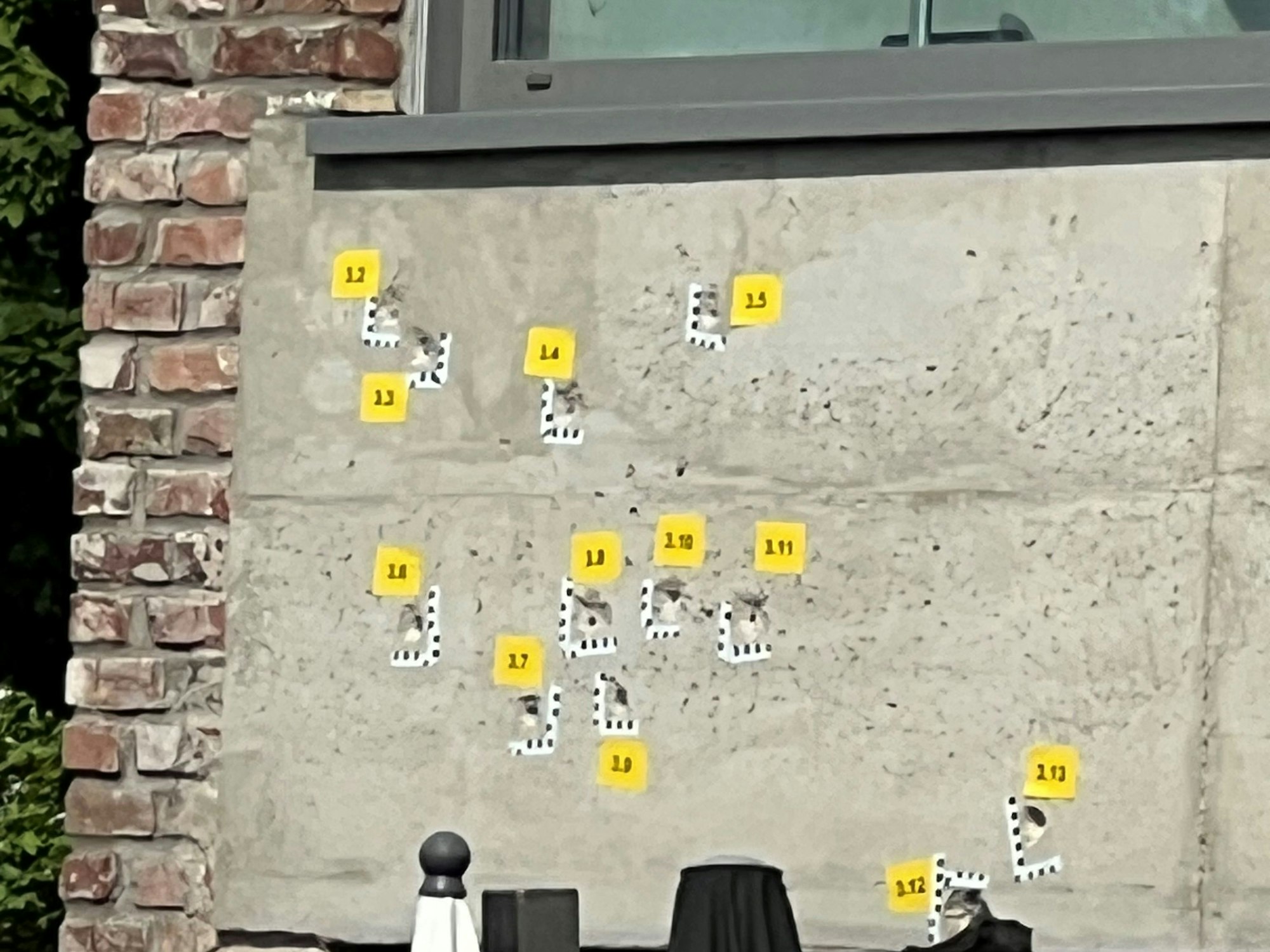 Das Bild zeigt eine betonierte Fassade mit mehreren Einschusslöchern.