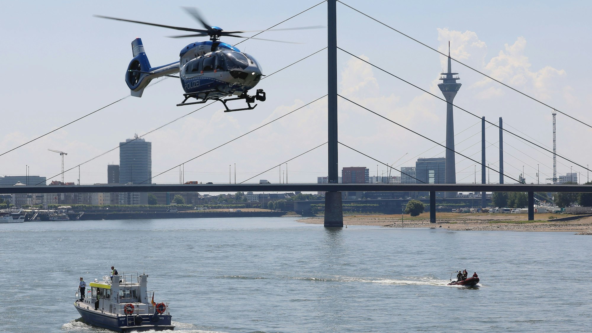 01.07.2025, Nordrhein-Westfalen, Düsseldorf: Feuerwehr und Polizei sind am Rhein mit mehreren Booten und einem Hubschrauber im Einsatz auf der Suche nach einer vermissten Person. Foto: David Young/dpa +++ dpa-Bildfunk +++