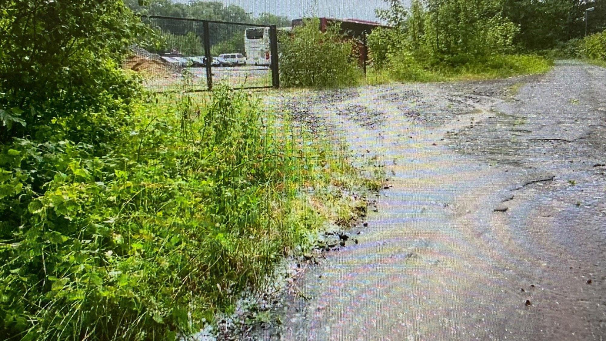 Zu sehen ist Wasser, das einen Weg hinunterläuft.