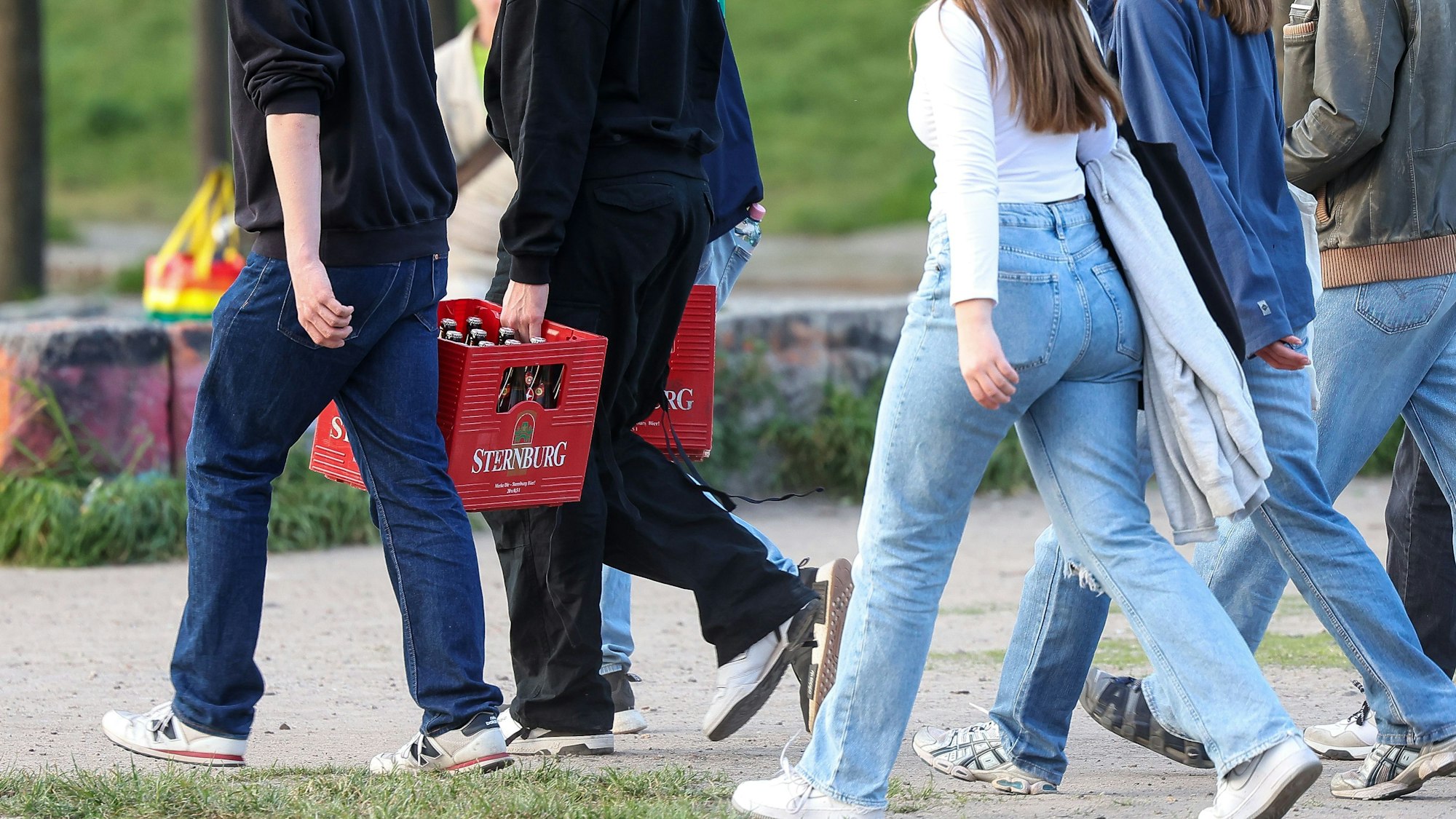 Mehrere junge Erwachsene tragen Bierkästen durch den Mauerpark. (Symbolbild)