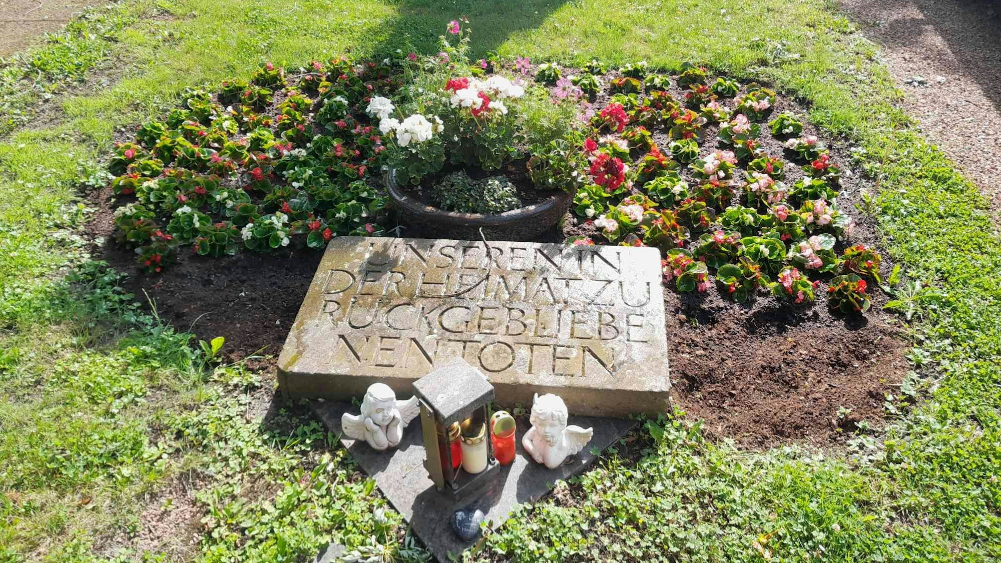 Auf dem Bild ist ein bepflanztes Ehrenmal zu sehen.