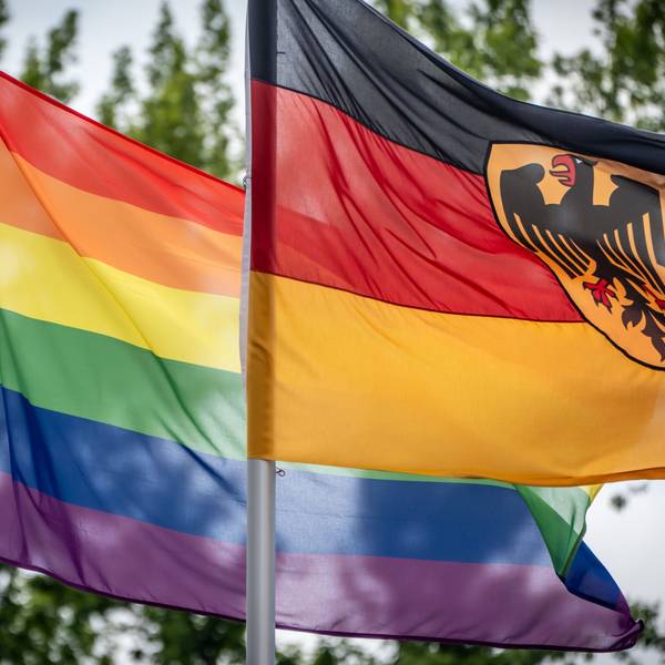 Das Bild zeigt eine Regenbogenflagge (l), die neben der Deutschlandfahne vor dem Bundesverteidiungsministerium weht. Foto: Michael Kappeler/dpa