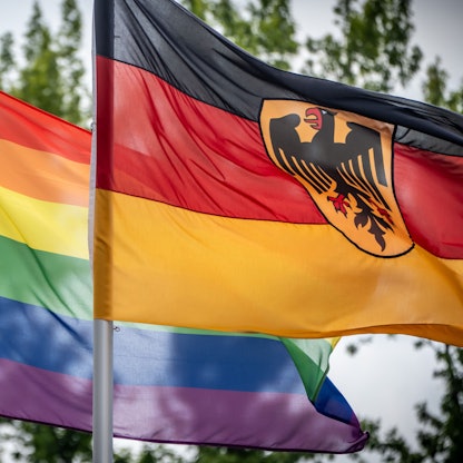 Das Bild zeigt eine Regenbogenflagge (l), die neben der Deutschlandfahne vor dem Bundesverteidiungsministerium weht. Foto: Michael Kappeler/dpa