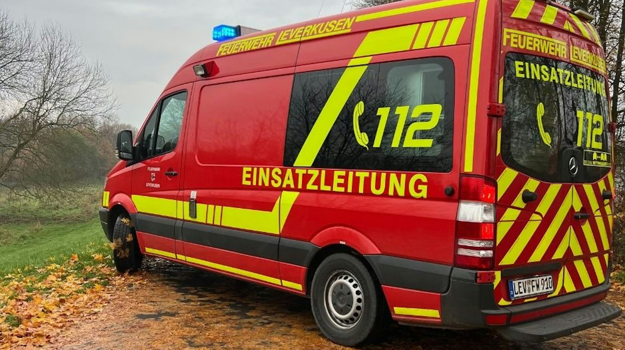 Einsatzkräfte der Feuerwehr Leverkusen bei der Brandbekämpfung eines Holzstapels in Schlebusch
