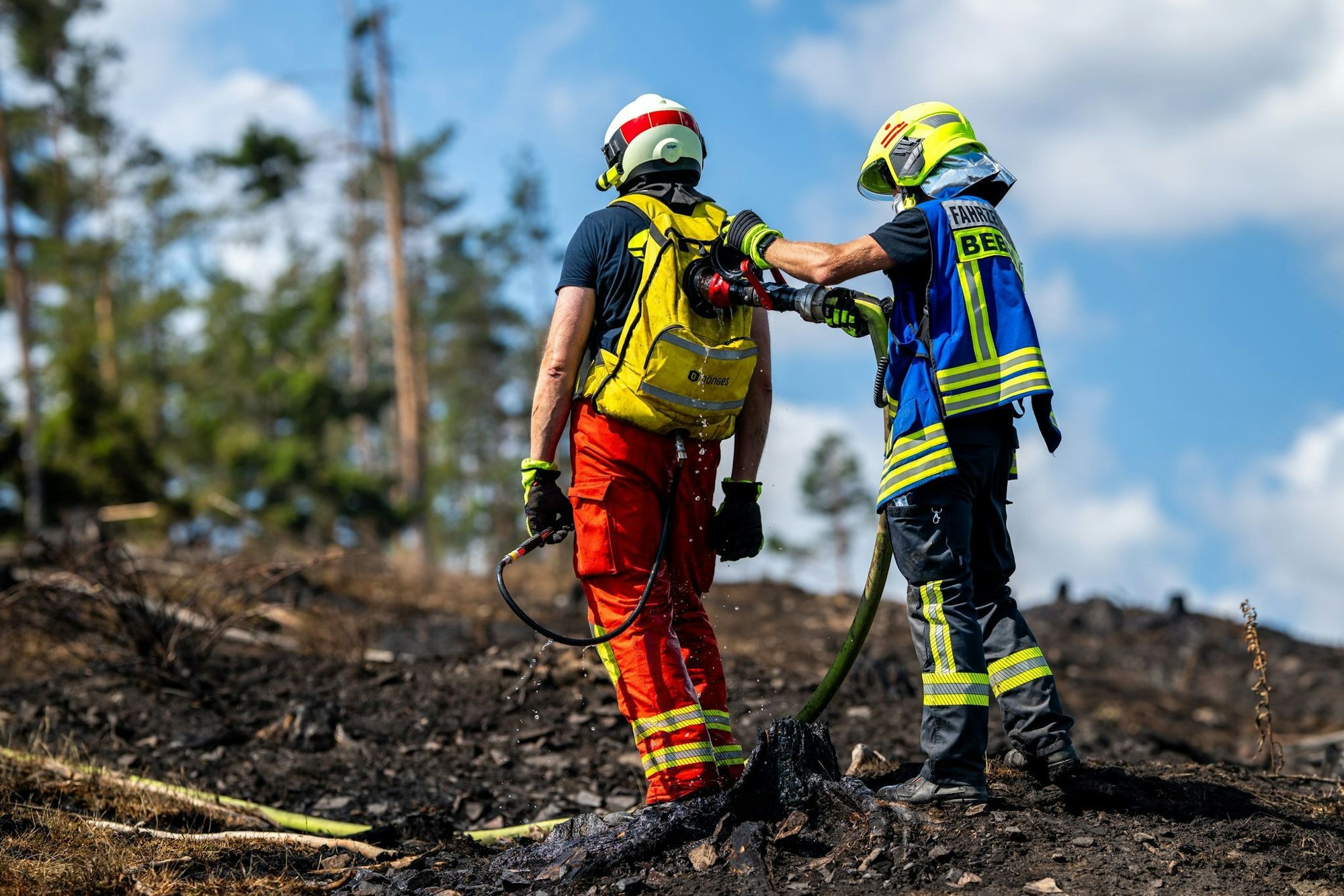 Mit Löschrucksäcken gehen die Feuerwehrleute etwa gegen Glutnester vor.