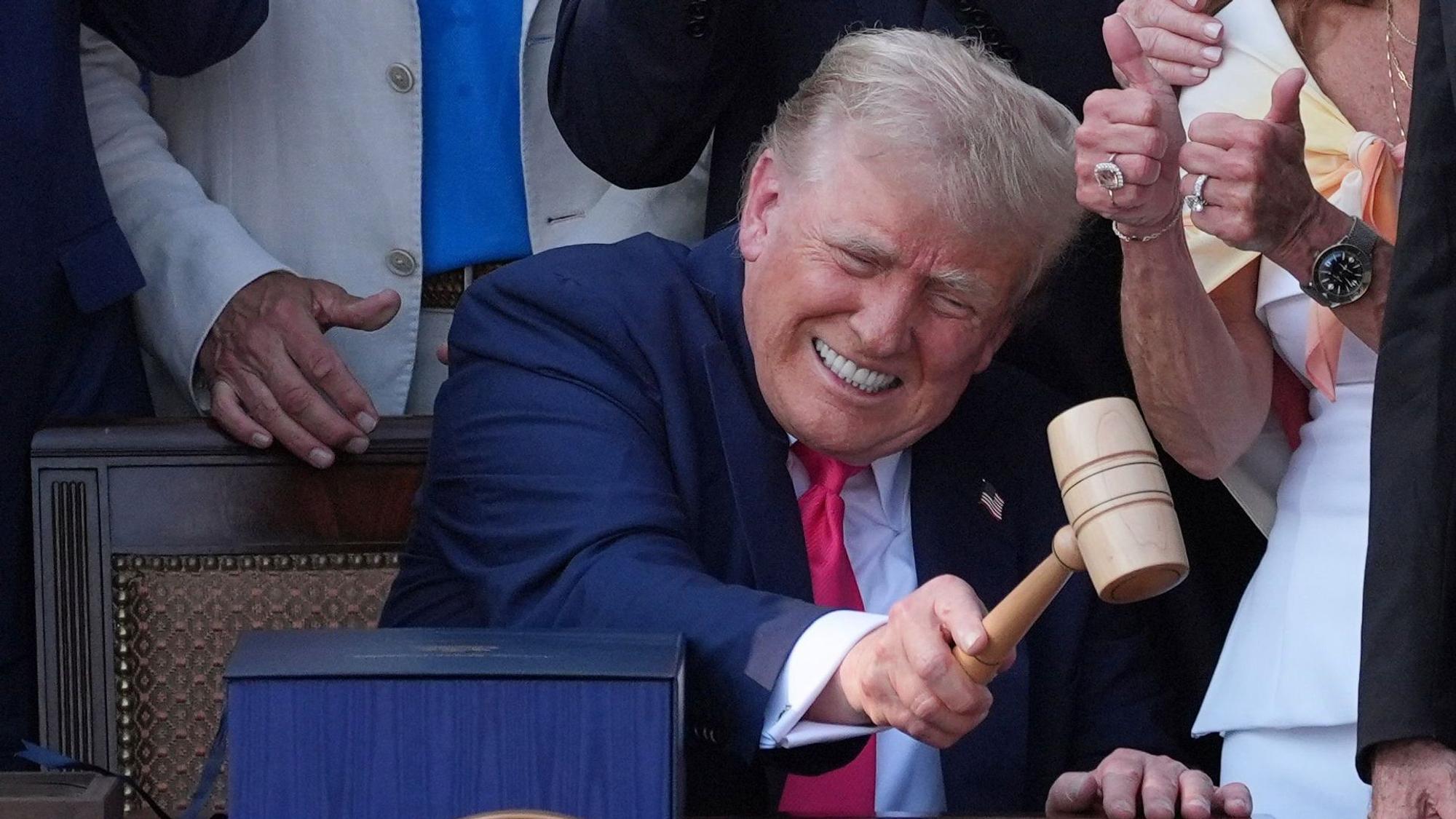 US-Präsident Donald Trump schlägt mit dem Hammer nachdem er sein Gesetz über Steuererleichterungen und Ausgabenkürzungen vor dem Weißen Haus unterzeichnet hat.