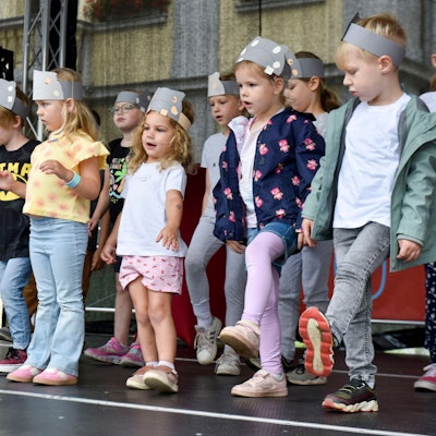 Kinder tanzen auf einer Bühne.
