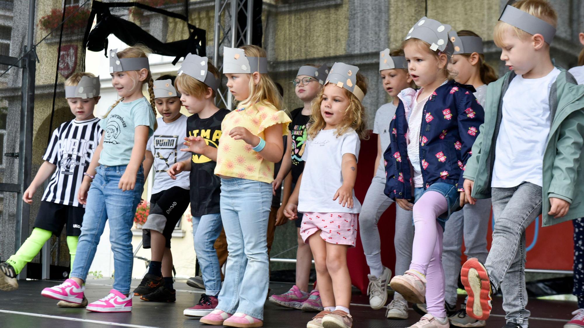 Kinder tanzen auf einer Bühne.