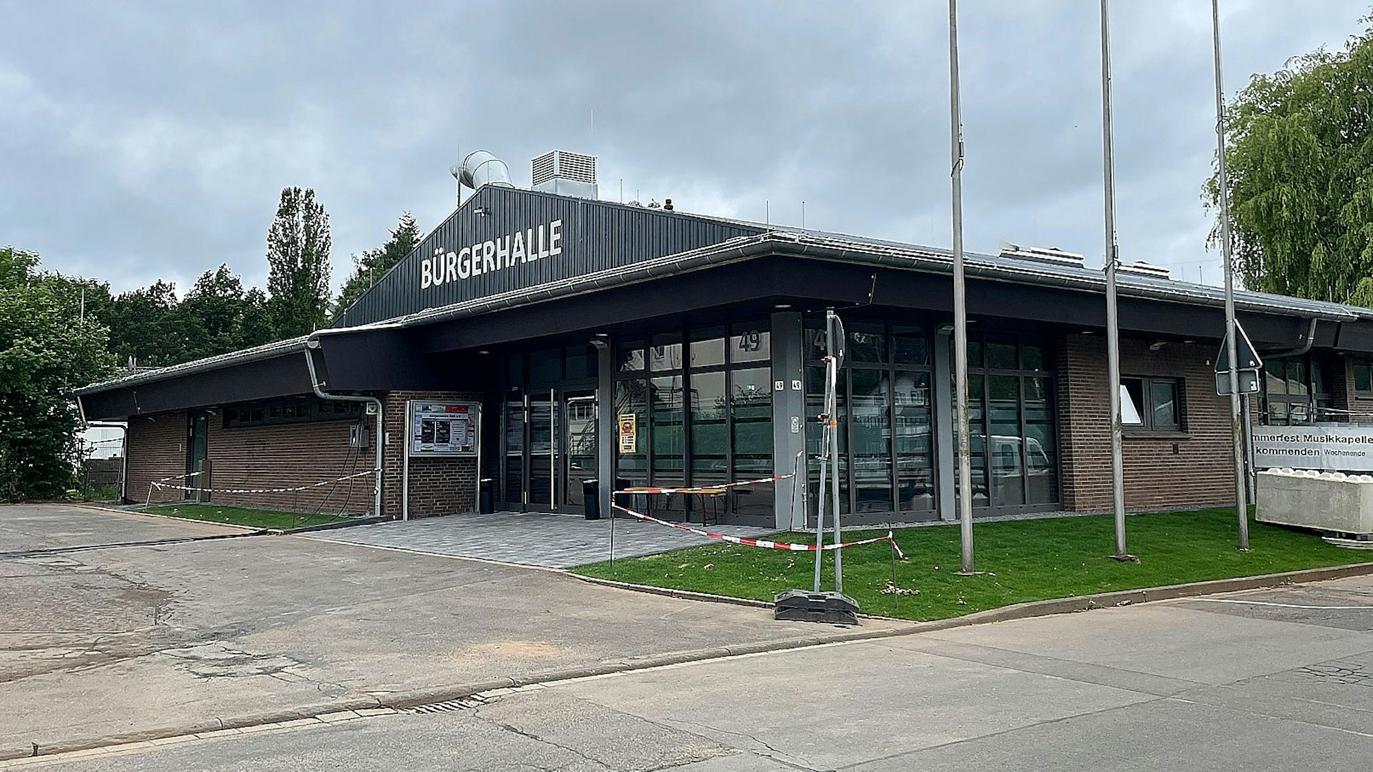 Das Bild zeigt ein Gebäude, auf dem in großen, weißen Buchstaben "Bürgerhalle" steht.