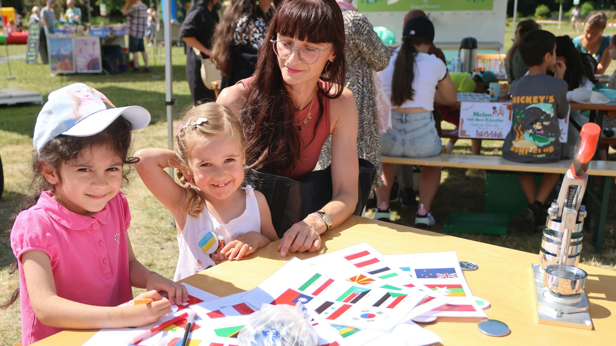 Spaß im Wiehlpark: Nelli (5) und Marie (3) malen mit ihrer Mutter Nataliya Fahnen nach. Das Begegnungsfest ist eines von dreien, das die Stadt am vergangenen Wochenende auf dem Freizeitgelände ausgerichtet hat.