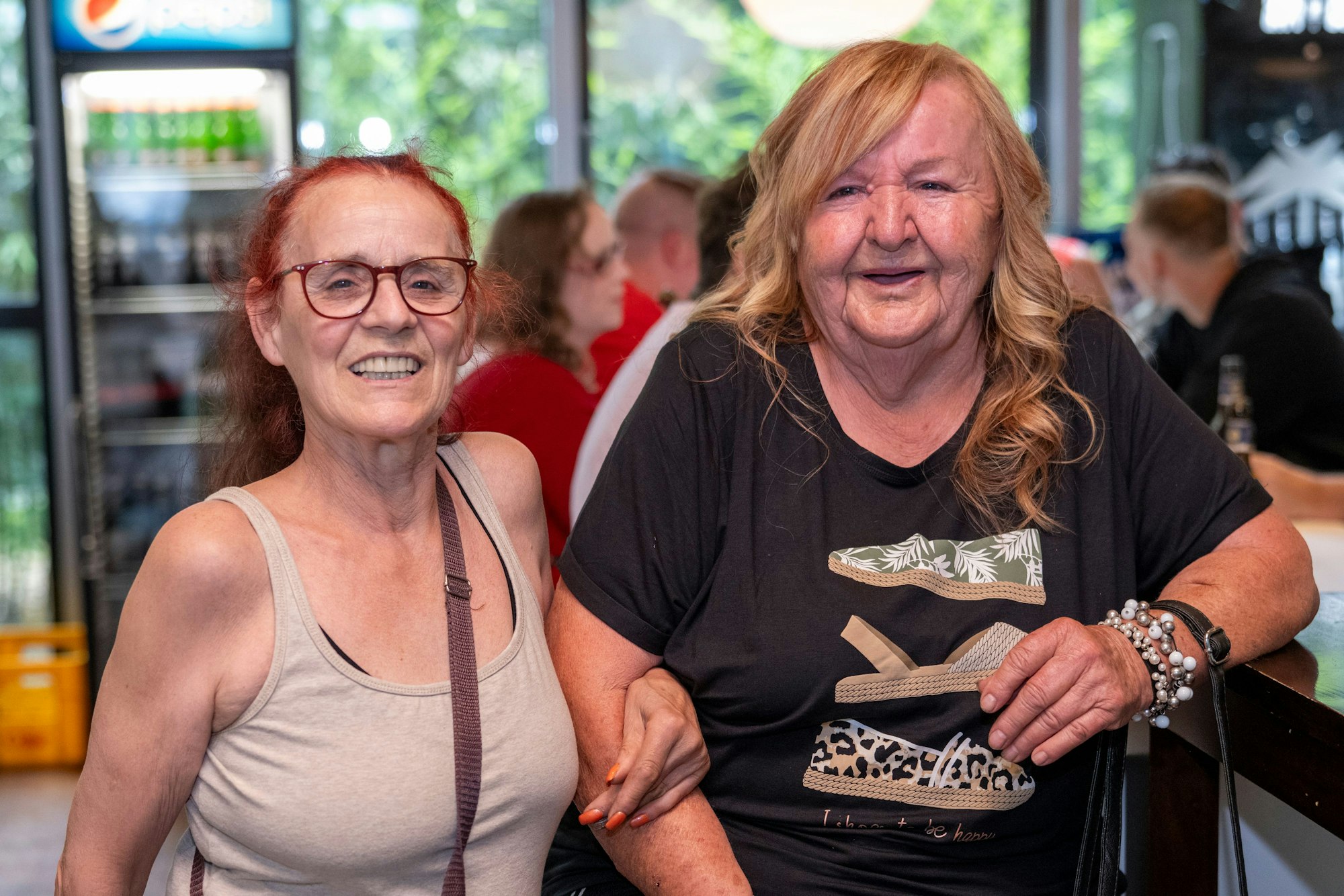 Zwei Frauen stehen nebeneinander und lächeln.