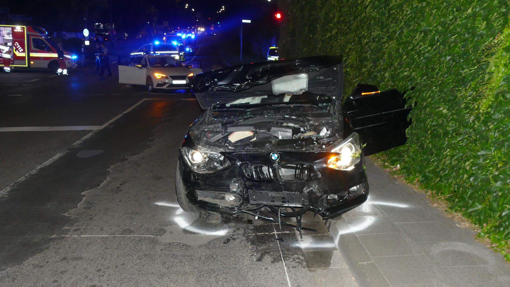 Ein an der Front und Fahrerseite stark zerstörtes Auto steht am Straßenrand.