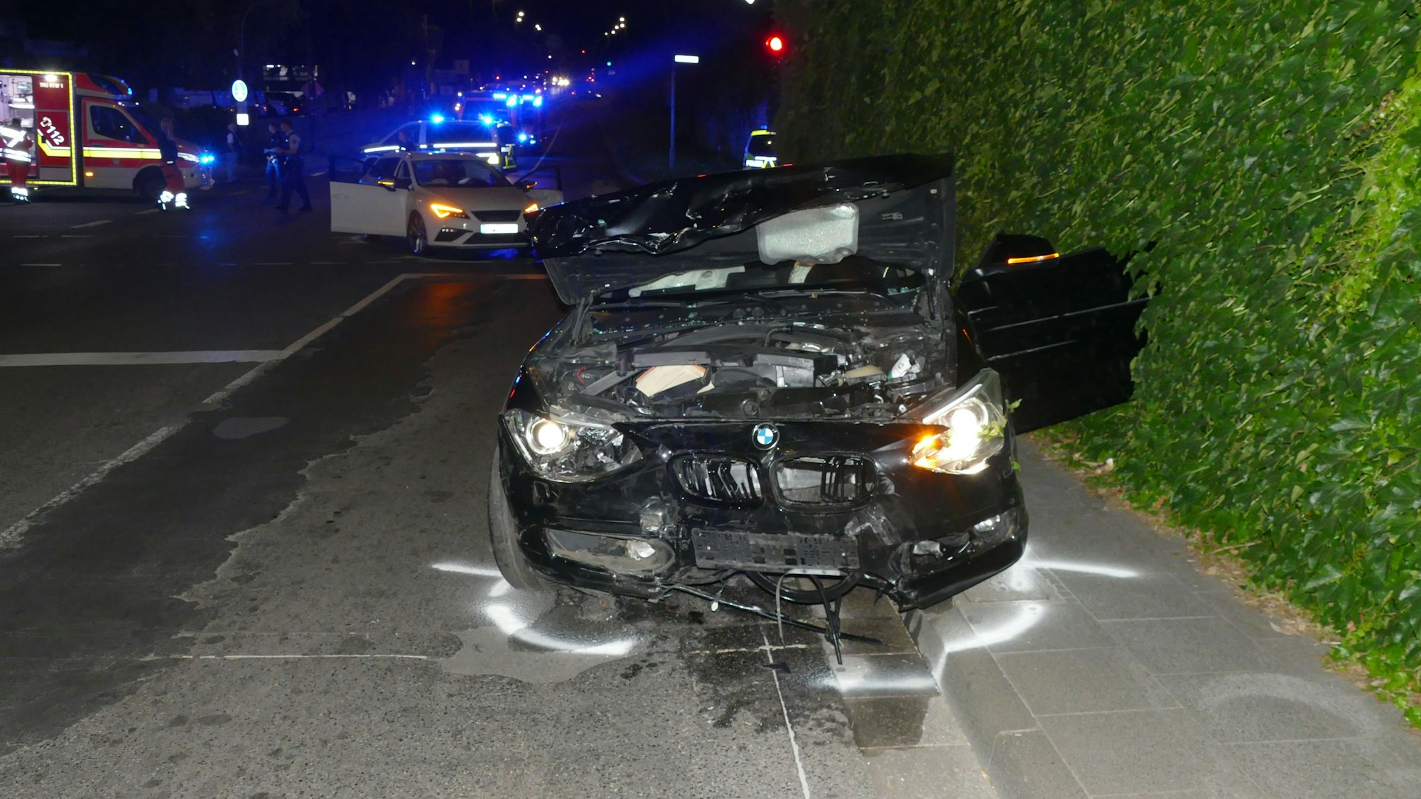 Ein an der Front und Fahrerseite stark zerstörtes Auto steht am Straßenrand.