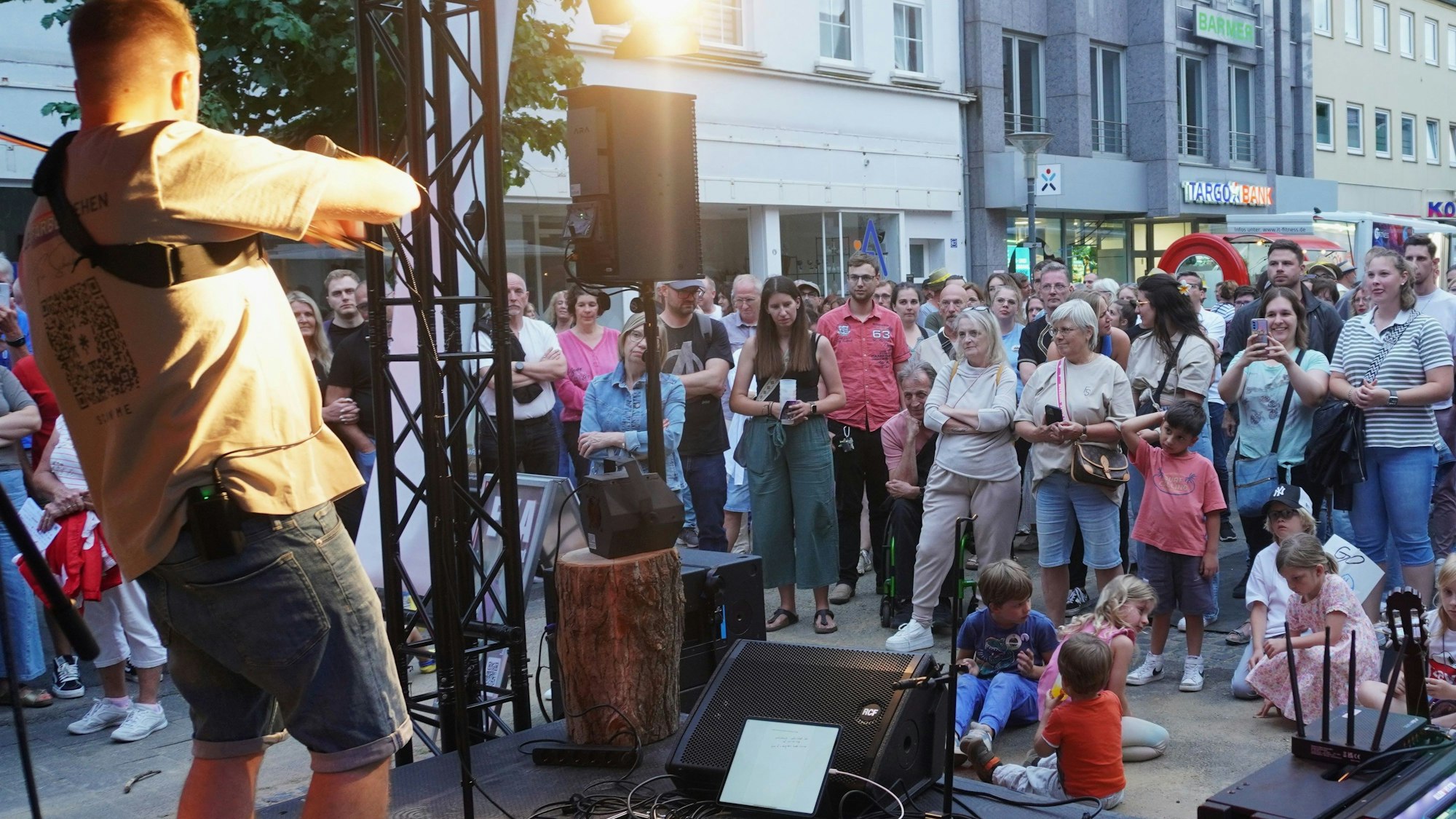 Vor einer Bühne lauscht das Publikum den Songs von Florian Scholdan.