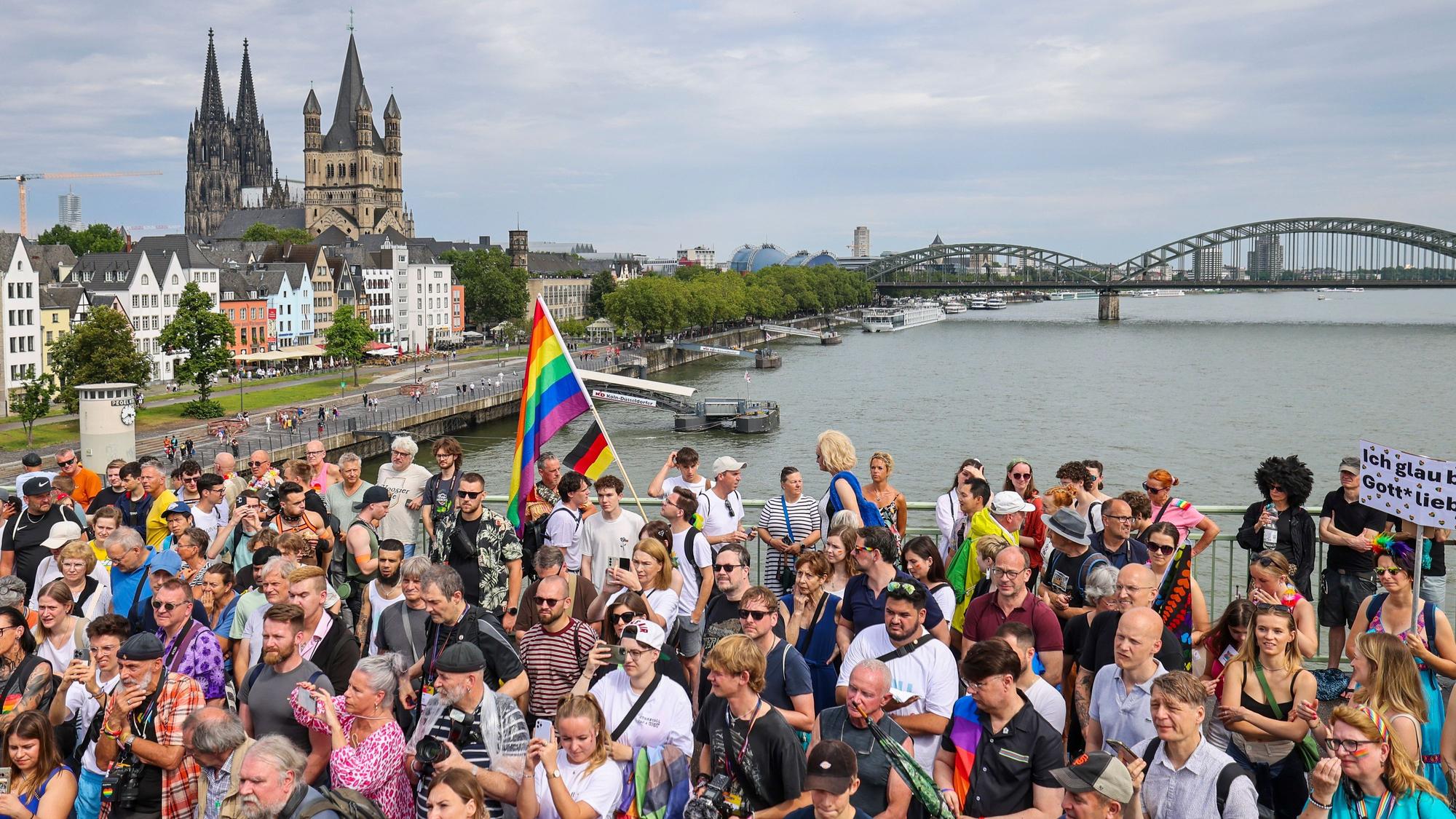 Eine Regenbogenflagge bei den Zuschauern beim CSD in Köln.