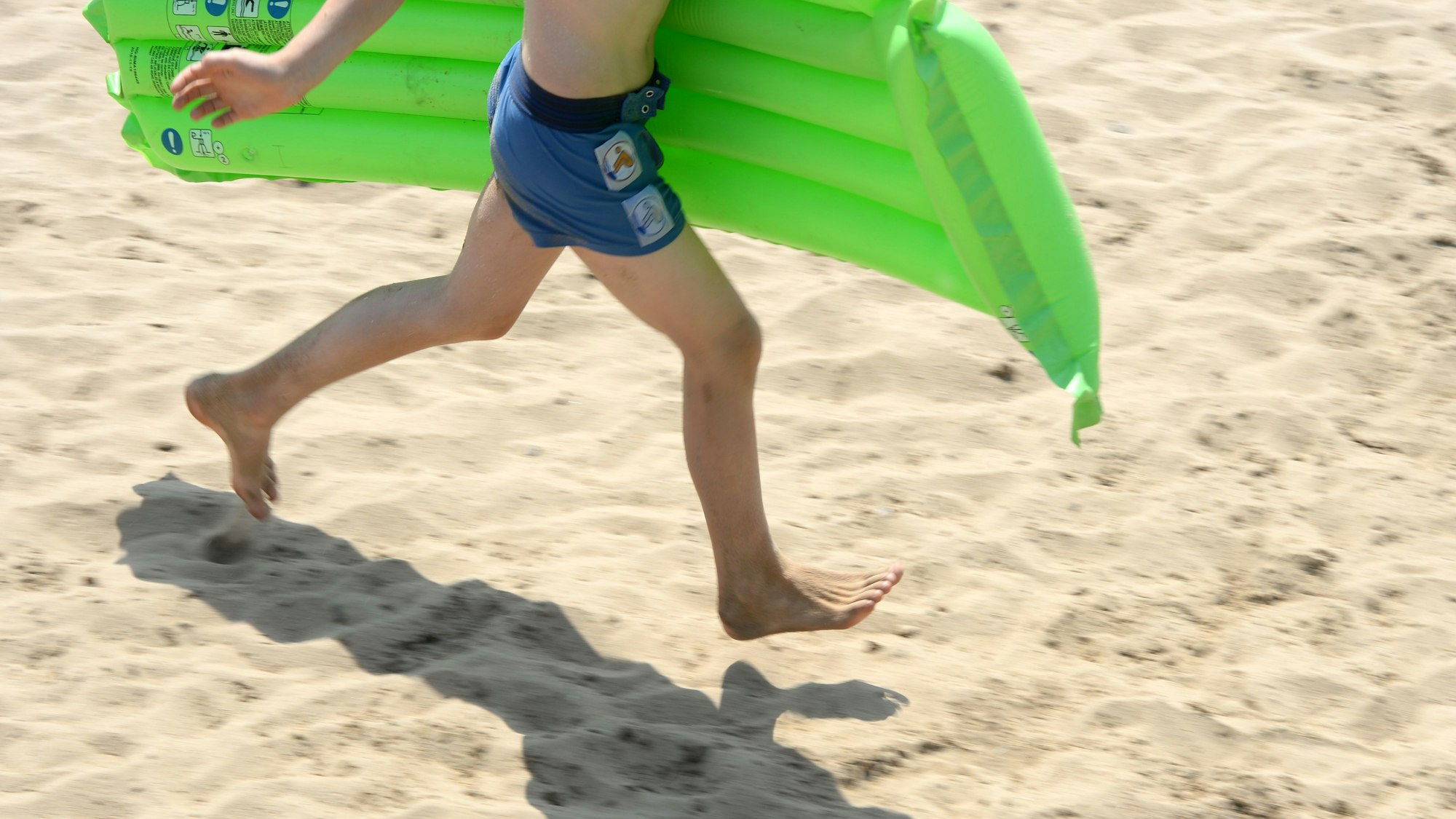 Das Symbolfoto zeigt ein Kind mit einer Luftmatratze. Ein Zwölfjähriger ist in der Eifel mehr als neun Kilometer weit mit einer Luftmatratze geschwommen.