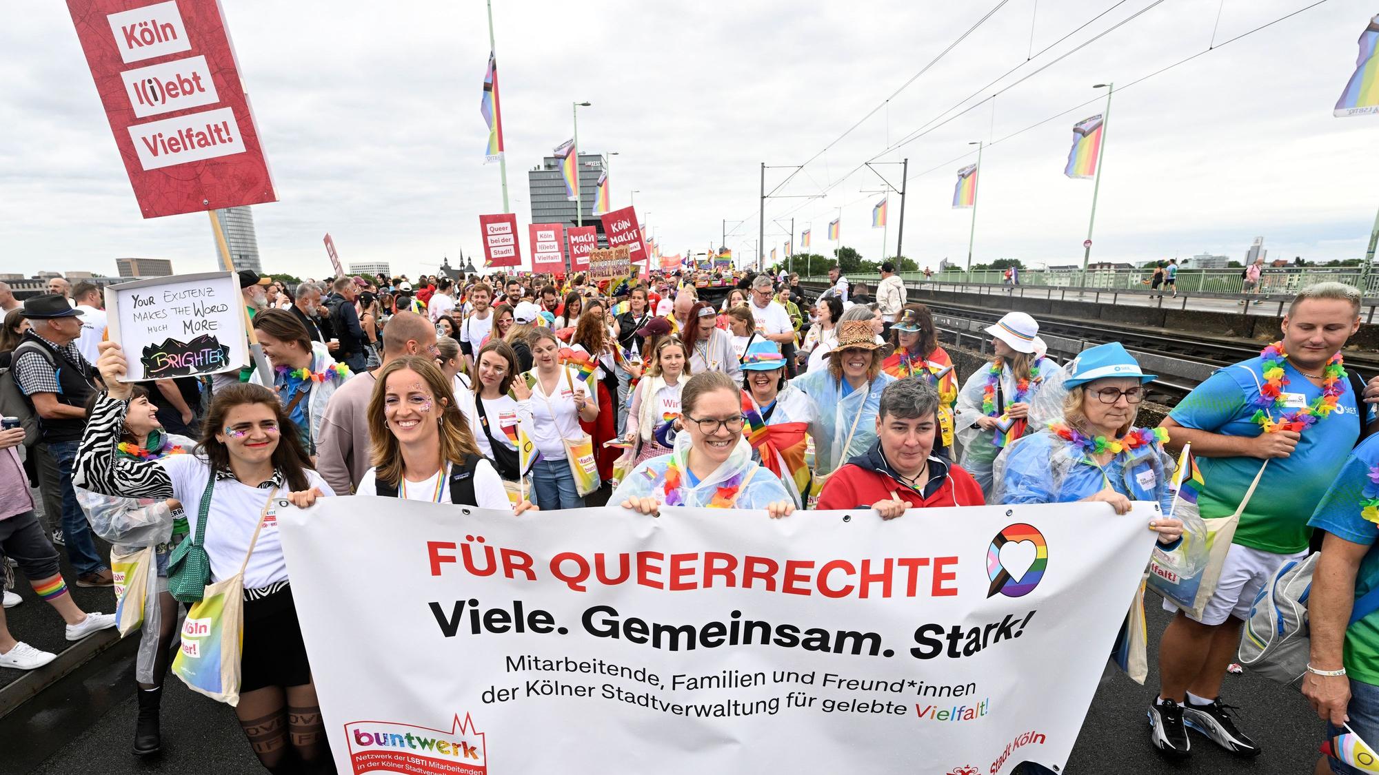 Teilnehmer des Christopher-Street-Day (CSD) Umzugs mit bunten Outfits zelebrieren ihren Protest in den Straßen der Stadt.