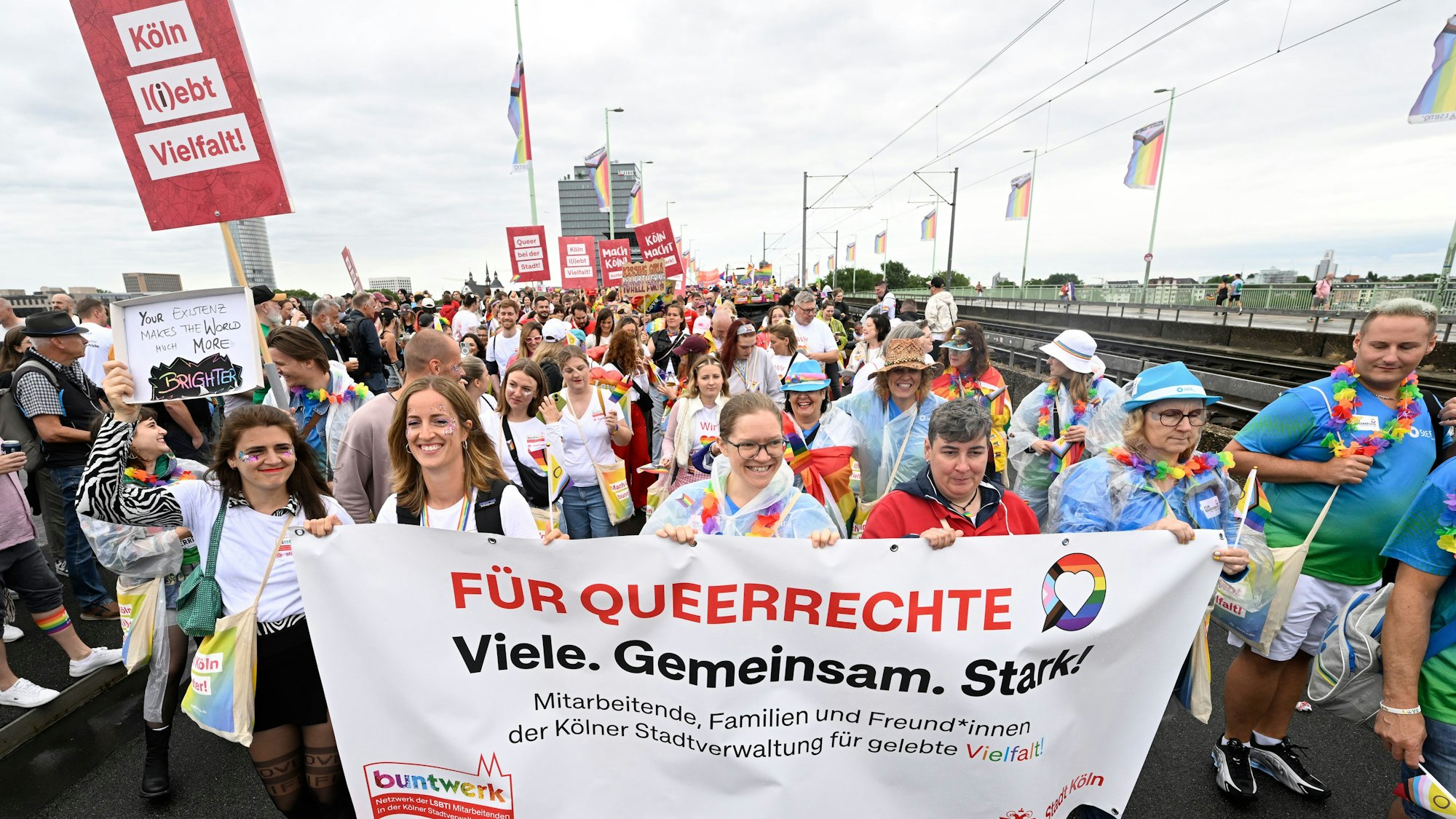 Teilnehmer des Christopher-Street-Day (CSD) Umzugs mit bunten Outfits zelebrieren ihren Protest in den Straßen der Stadt.